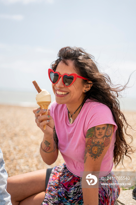 Smiling woman eating ice cream on beach