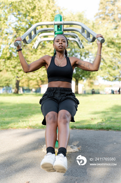 Young woman working out in outdoor gym