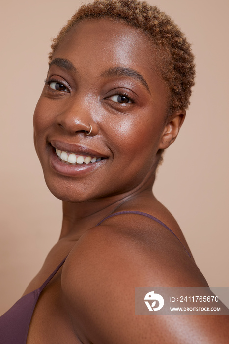 Studio portrait of smiling woman with nose ring