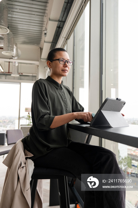 Woman using digital tablet in office