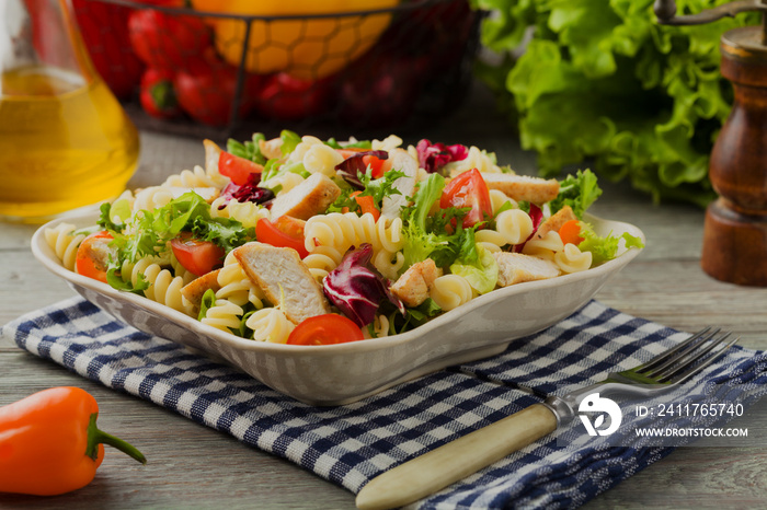 Noodle salad with green lettuce, tomatoes and roasted chicken.