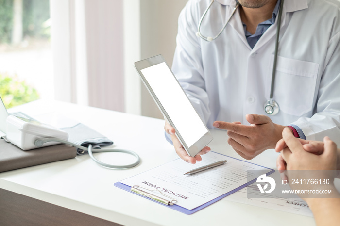 Doctor guides the patient through a blank screen tablet At the doctor’s office.