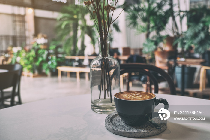 A black cup of hot coffee on table in cafe