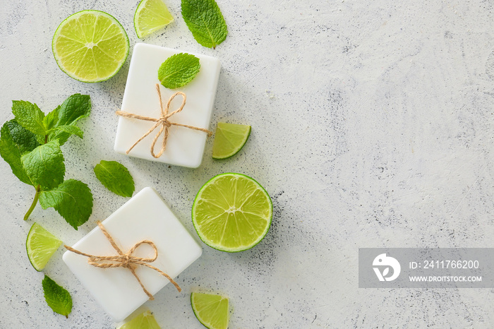 Soap bars, lime and mint on light background