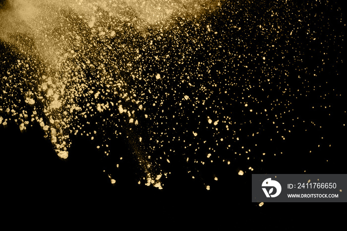 Golden powder explosion on black background. Freeze motion.