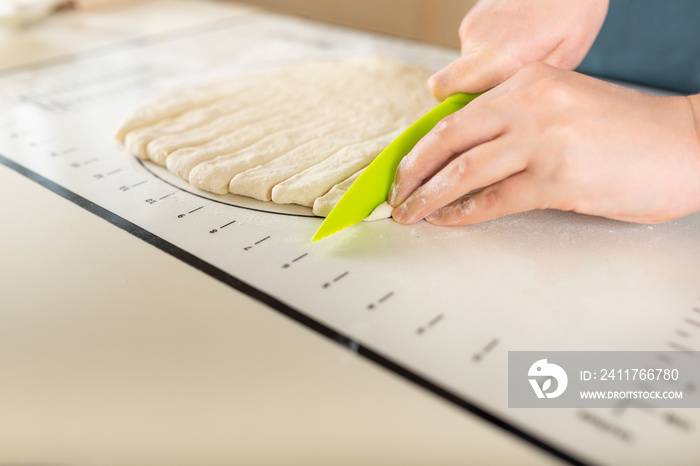 Side view on process of cooking from dough on a baking mat with markings on the kitchen table, copy space.