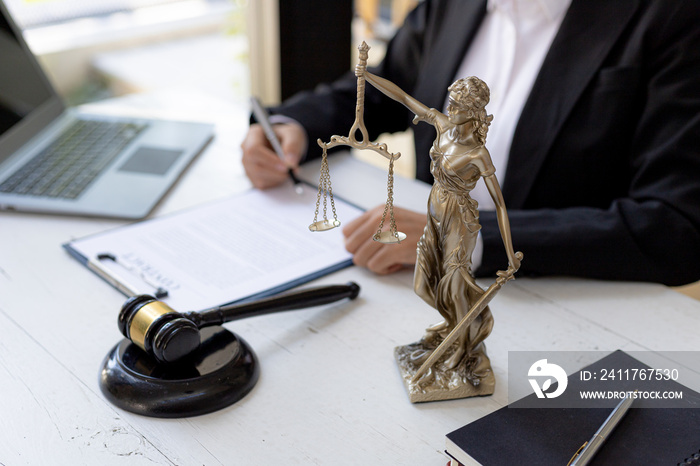 Lawyer’s Desk On the table is a statue of Themis who is the goddess of justice and the hammer of justice, lawyers often praise her as a symbol of justice. Concept of law and justice.