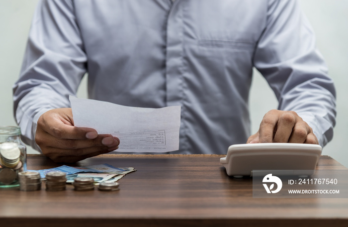 Man with bill and stack of coin on business office table vintage style