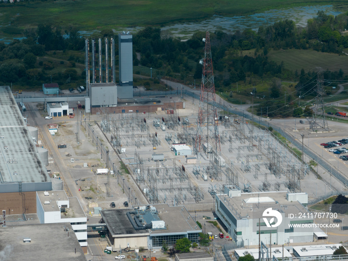 A high-angle aerial view looking at an electrical transformer, power grid station. Seen on a sunny day.