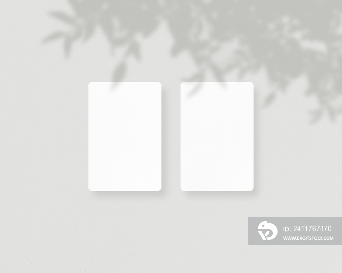 Blank white business cards mockups with soft shadow. Mockup of two vertical business cards. Mockup scene. Photo mockup with clipping path.