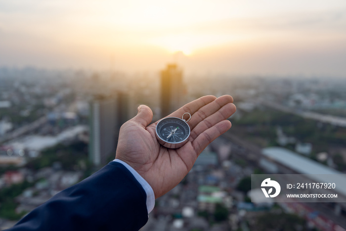 Businessman holding a navigation compass in hand and define marketing direction, Abstract business