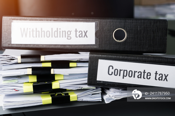 Tax concept, Withholding taxes binders files on document report in business office. Retention taxes is income tax to be paid to government by payer of income rather than by recipient of the income.