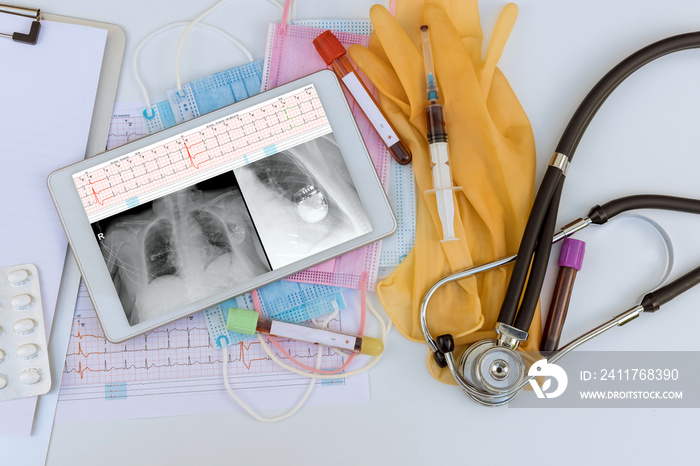 Doctor checks the correctness work of after installed pacemakers, X-ray chest and electrocadiogram of wave report in digital the tablet view