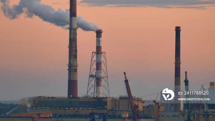 Smoke Fumes Raising from Industrial Chimney at Sunrise