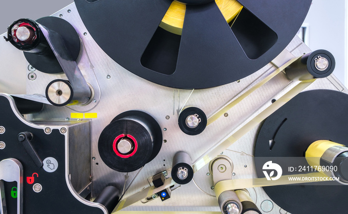 Fragment of the conveyor of sticking labeling machine. Abstract industrial background.