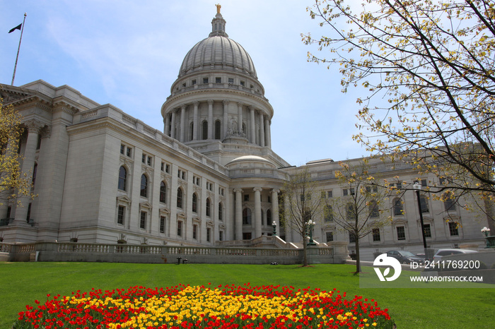 Wisconsin State Capitol building spring view with flower bed with bright tulips on a foreground. City of Madison, the capital of Wisconsin, Midwest USA.