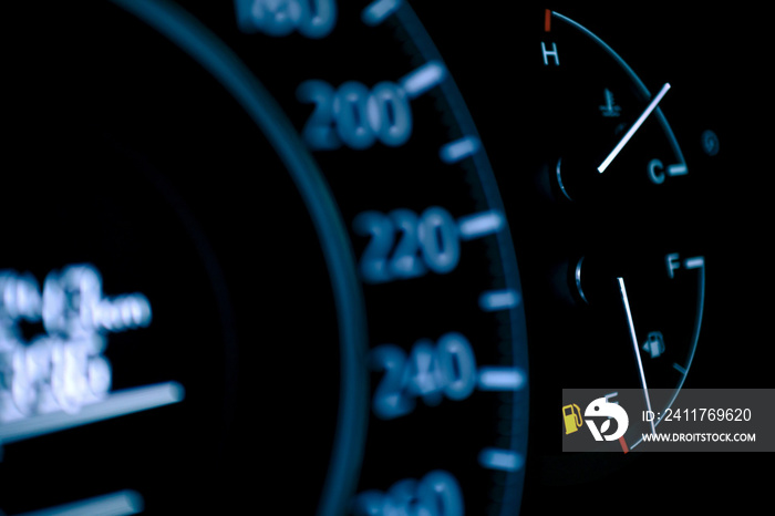 car dashboard shows low fuel warning light, selective focus