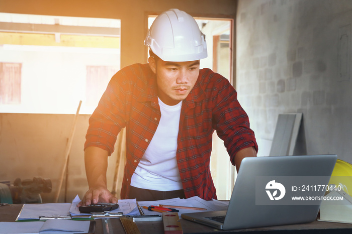 architect man working with laptop and blueprints,engineer inspection in workplace for architectural plan,sketching a construction project ,selective focus,Business concept vintage color