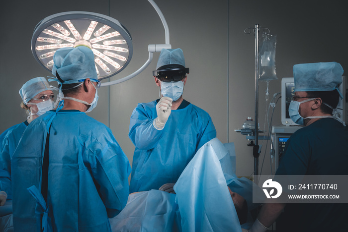 Group of surgeons using augmented reality holographic hololens glasses while operating in modern operation theater