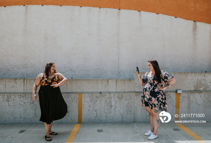 woman photographs another woman with phone