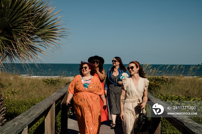 4 friends walk on boardwalk