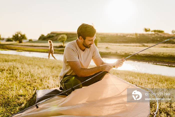 White man using setting up her tent during hiking outdoors