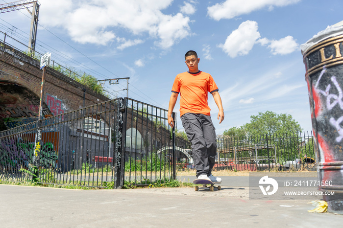 Young man skateboarding on footpath