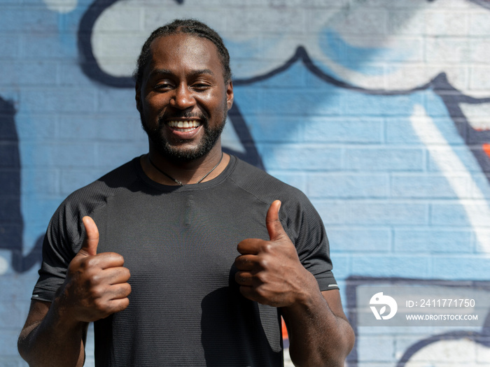 Portrait of smiling man showing thumbs up