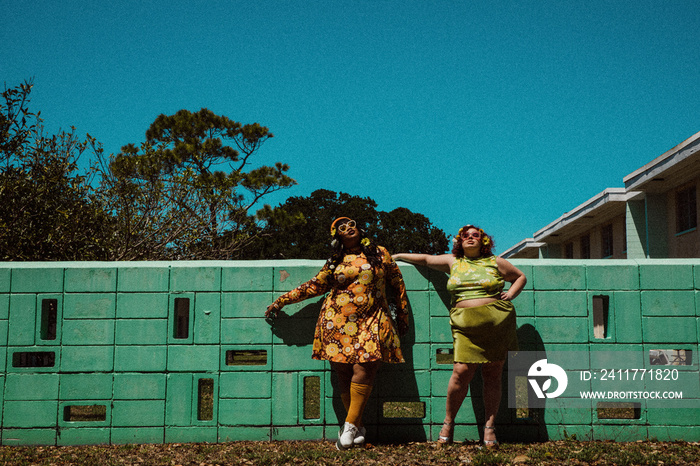 2 plus size women stand outside with sunglasses on