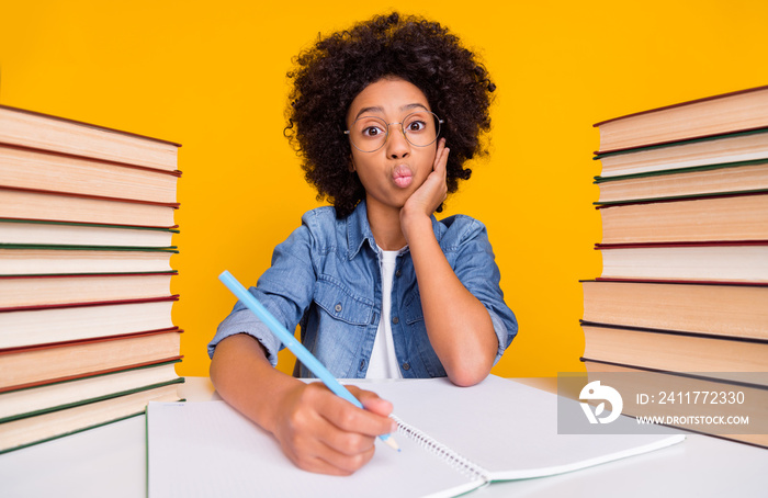 Portrait of attractive trendy cheery funny teen girl writing domestic work pout lips maths isolated over bright yellow color background