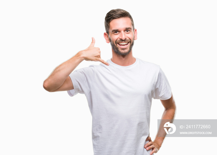 Young handsome man over isolated background smiling doing phone gesture with hand and fingers like talking on the telephone. Communicating concepts.