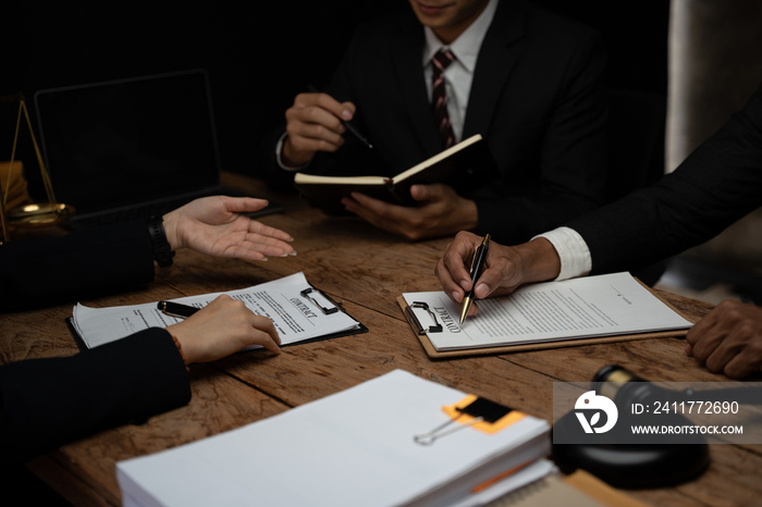 Close up lawyer businessman working or reading lawbook in office workplace for consultant lawyer concept.Lawyer working at table in office, focus on scales of justice