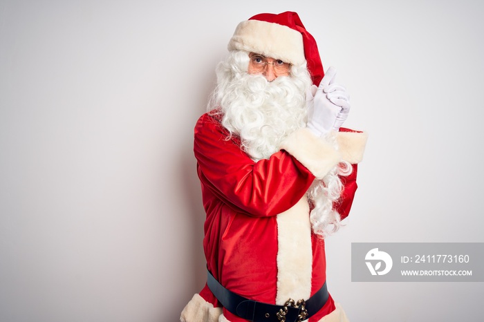 Middle age handsome man wearing Santa costume standing over isolated white background Holding symbolic gun with hand gesture, playing killing shooting weapons, angry face