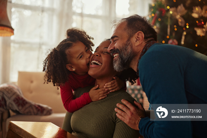 Loving mixed race family hugging at home