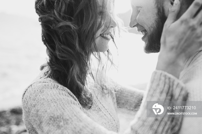 Close-up portrait of man and woman together, happy, looking at each other. Smiling, kissing and laughing. Black and white toning