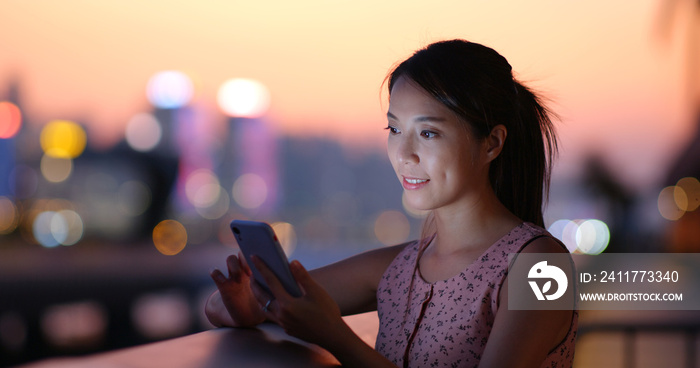 Woman check the location on cellphone in city of Hong Kong at sunset time