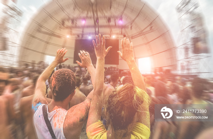 Happy friends having fun in color dust concert festival outdoor - Young people dancing at sunset in summer party - Youth and friendship concept with multi colored powder game