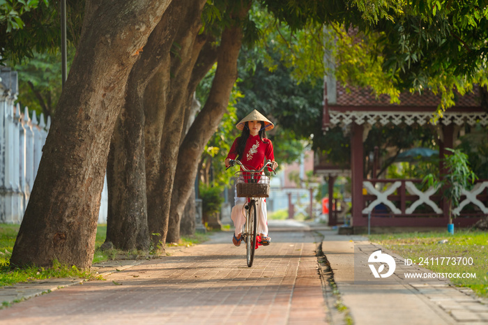 Portrait of Vietnamese girl traditional red dress,Beautiful young asian woman wearing Vietnam with bicycle