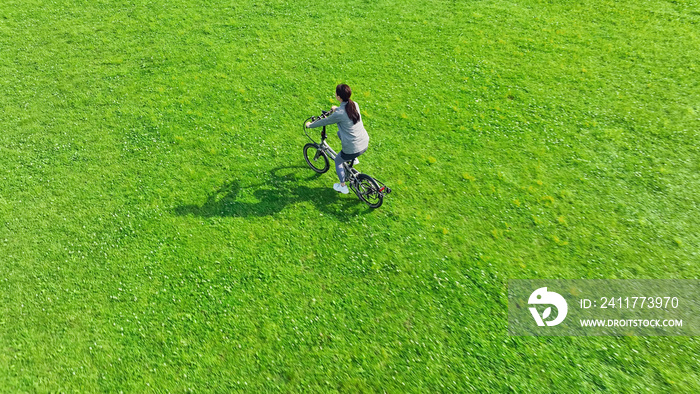 草原を自転車で走る女性