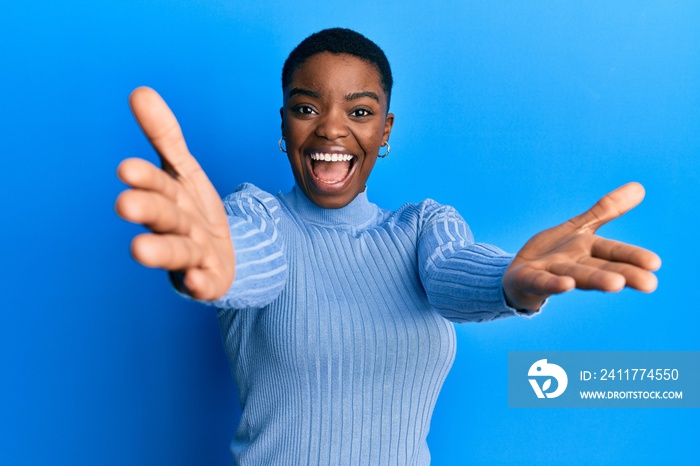 Young african american woman wearing casual clothes looking at the camera smiling with open arms for hug. cheerful expression embracing happiness.