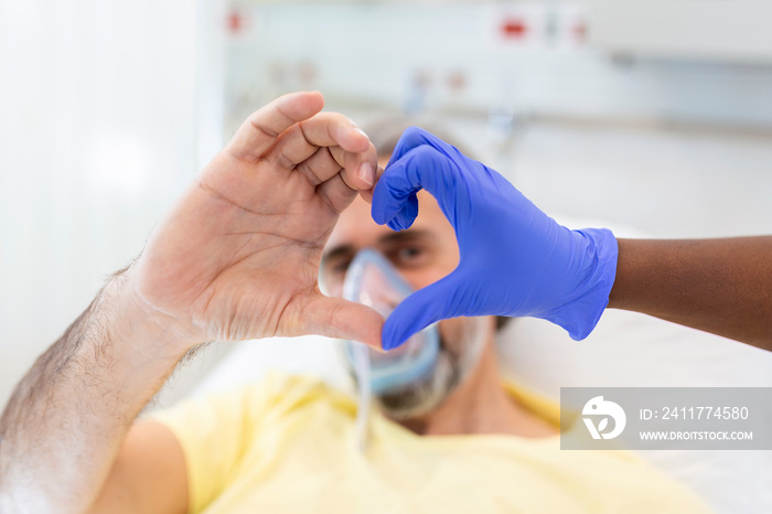 Doctor and patient make finger heart shape wearing blue disposable latex glove, rubber glove for professional medical safety and hygiene protection from Coronavirus disease COVID-19 and surgery