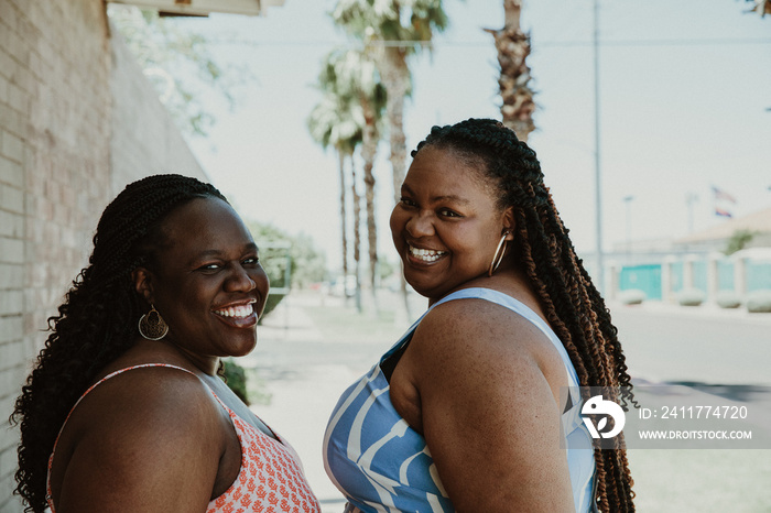 closeup of 2 plus size African American women look over shoulder