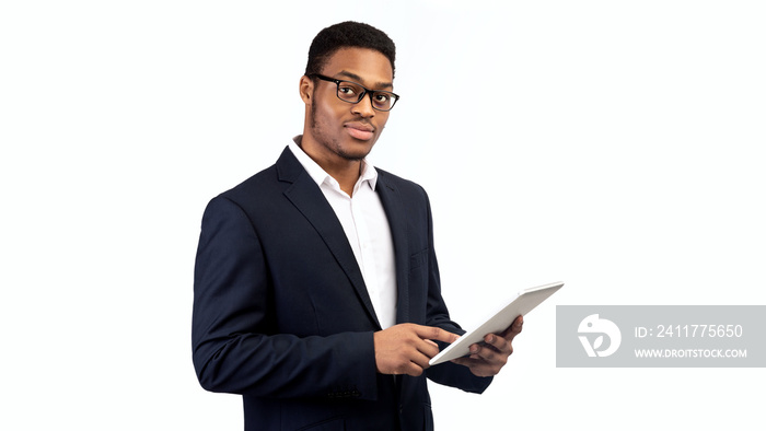 Black guy in suit standing with tablet