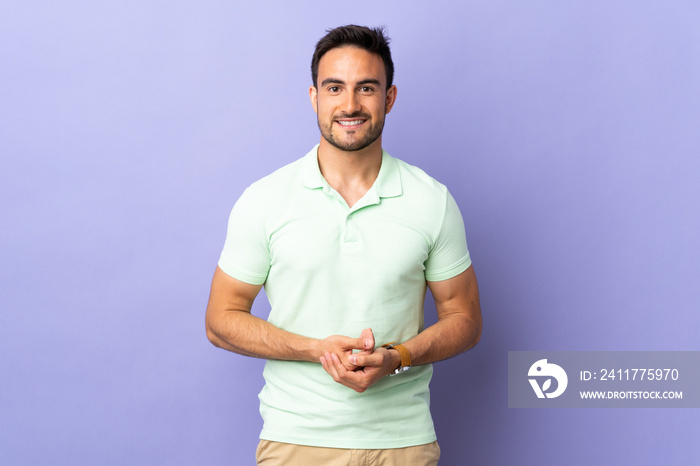 Young handsome man isolated on purple background laughing