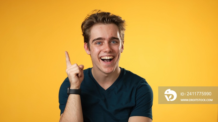 Portrait of thinking, smart puzzled pensive young hipster man 20s looks around thinks comes up with ideas raised finger isolated on yellow background studio portrait