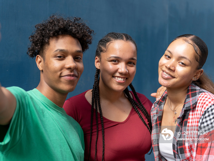 Portrait of friends against blue wall