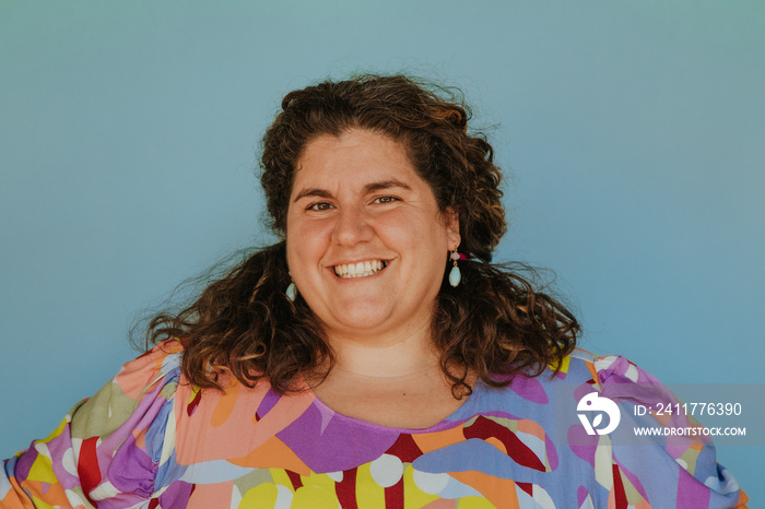 closeup of plus size woman smiling on blue background