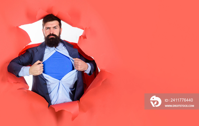 Through paper. Business growth. Businessman. Bearded man looking through paper. Super businessmen showing blue shirt. Superhero. Superman Cape. Hero. Symbol S. Super power.