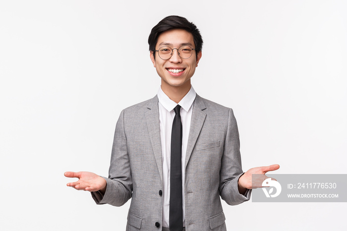 Waist-up portrait of friendly-looking handsome young asian man in business suit, giving two object, variants red and blue pill, smiling as offer make decision, holding something on palms