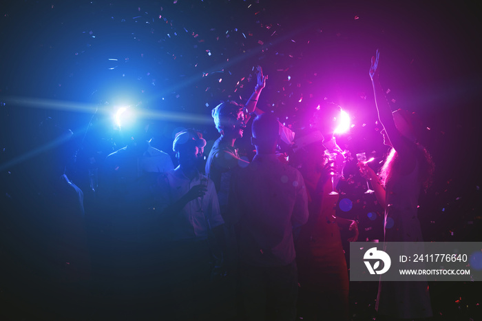 Young friends dancing while having celebration at club